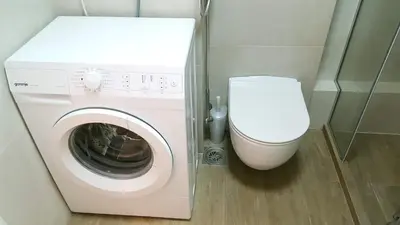 a washing machine and a toilet in a bathroom at Arena Relax Apartman in Belgrade