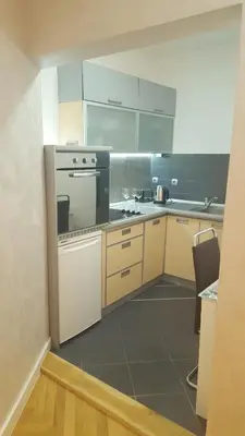 a kitchen with white cabinets and a stove at Arena Relax Apartman in Belgrade