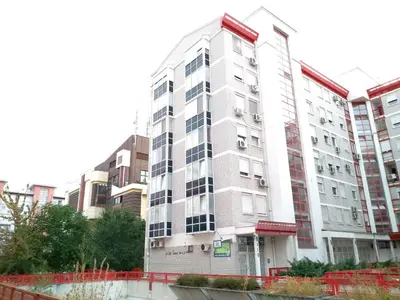 a tall white apartment building in a city at Arena Relax Apartman in Belgrade