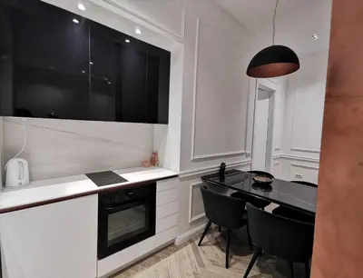 a kitchen with a black counter top and black chairs at Max Central Apartment in Belgrade