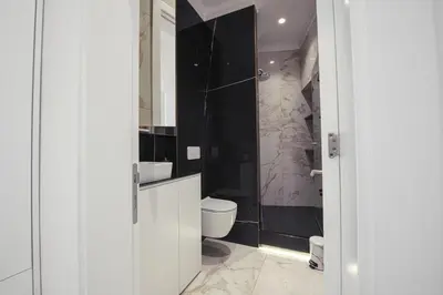 a bathroom with a toilet and a glass shower at Max Central Apartment in Belgrade