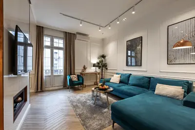 a living room with a blue couch and a table at Max Central Apartment in Belgrade
