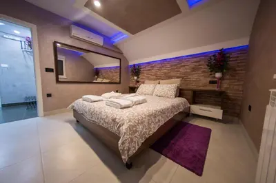 a bedroom with a large bed and a brick wall at Vila Argola - Spa Luxury Apartments in Belgrade