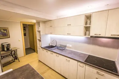 a kitchen with white cabinets and a sink at HostGost Selected Suites - BAMS, Private Spa included in Belgrade