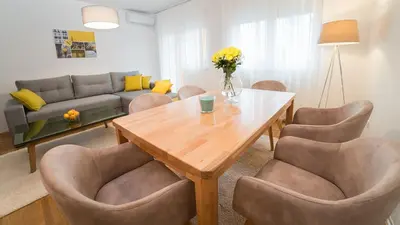 a living room with a table and chairs and a couch at Novel Inn in Belgrade