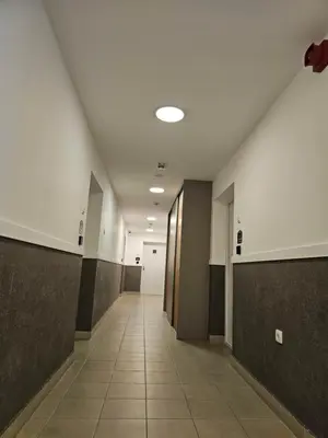 a hallway of an office building with doors and a tile floor at Novel Inn in Belgrade