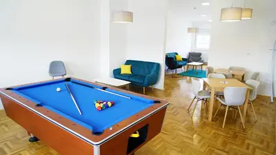 a room with a pool table and a dining room at Novel Inn in Belgrade