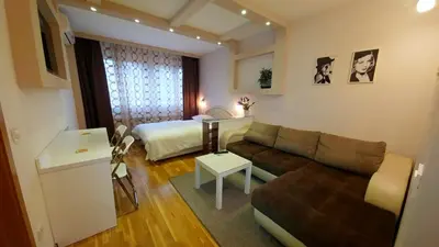 a small living room with a couch and a bed at Apartment OASIS in Belgrade