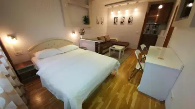 a bedroom with a white bed and a living room at Apartment OASIS in Belgrade