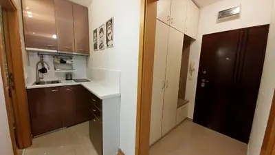 a kitchen with white cabinets and a black door at Apartment OASIS in Belgrade