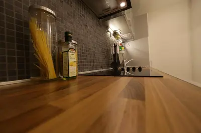 a room with a wooden floor and a bottle of alcohol at Apartment Piano in Belgrade