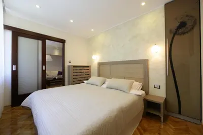 a bedroom with a large bed with white sheets at Apartment Piano in Belgrade