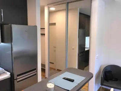 a kitchen with a stainless steel refrigerator and a table at Zaza apartman in Belgrade
