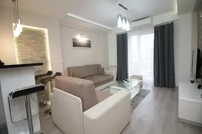 a white living room with a couch and a table at Diva Lux Apartman in Belgrade