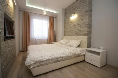 a bedroom with a bed and a brick wall at Diva Lux Apartman in Belgrade