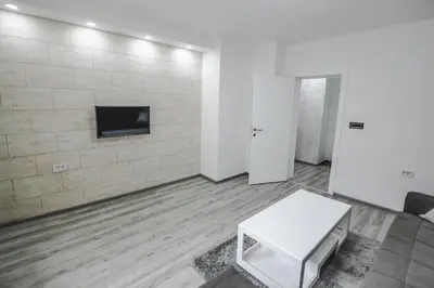 a room with a white table and a tv on a wall at Kristal Apartmani in Arandjelovac