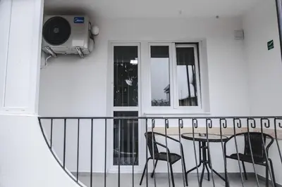 a balcony with a table and chairs and a window at Kristal Apartmani in Arandjelovac