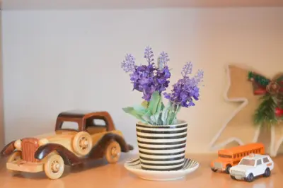 a vase with purple flowers in it next to toy trucks at Central and modern in Belgrade