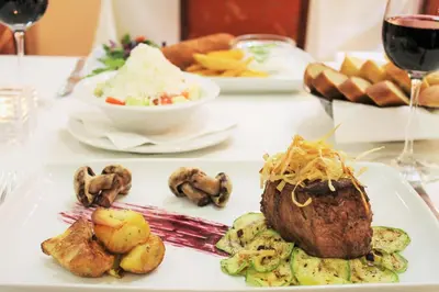 a table with a plate of food on a table at Hotel Rex in Belgrade