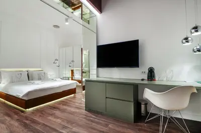 a bedroom with a bed and a desk with a television at Room 25 Belgrade in Belgrade