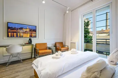 a white bedroom with a bed and a large window at Room 25 Belgrade in Belgrade