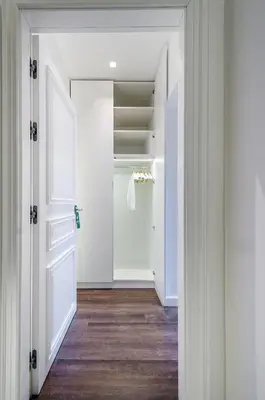 a hallway with a closet with white doors and wood floors at Room 25 Belgrade in Belgrade