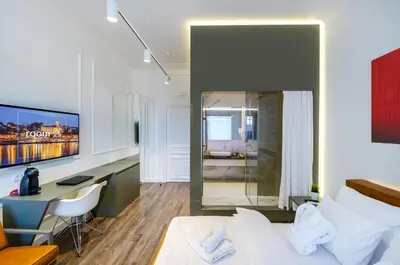 a bedroom with a bed and a desk with a computer at Room 25 Belgrade in Belgrade