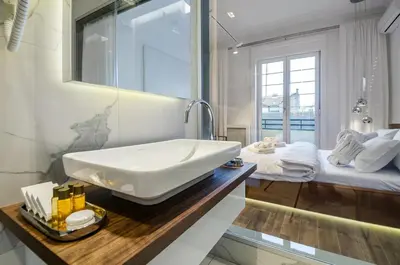 a bathroom with a white sink and a bed at Room 25 Belgrade in Belgrade