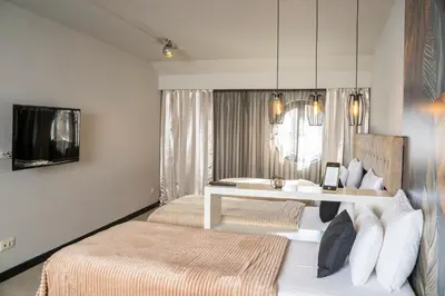 a hotel room with two beds and a desk at Akacija Luxury Suites- Zemunski kej in Belgrade