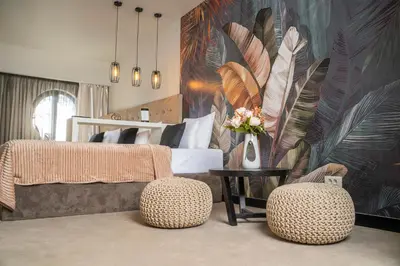 a bedroom with a bed with a large mural of feathers at Akacija Luxury Suites- Zemunski kej in Belgrade