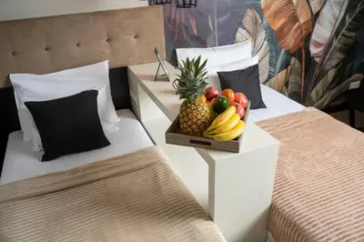 two beds with a tray of fruit on them at Akacija Luxury Suites- Zemunski kej in Belgrade