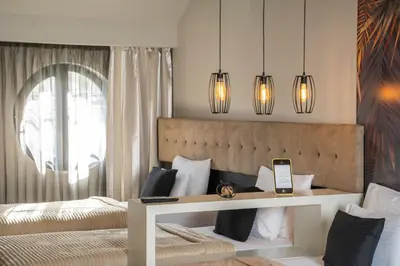 a bedroom with a bed and a table with a cell phone at Akacija Luxury Suites- Zemunski kej in Belgrade