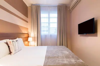 a bedroom with a bed and a television on a wall at Apartments Top Central 3 in Belgrade