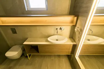 a bathroom with a sink and a toilet and a mirror at Garni Hotel D10 in Belgrade