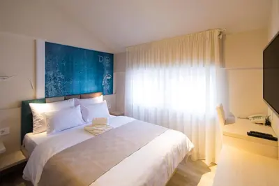 a bedroom with a large bed with a blue wall at Garni Hotel D10 in Belgrade