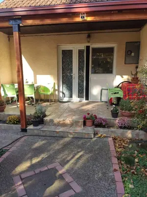 a front porch with green chairs and a patio at Apartment Ljupka in Pančevo