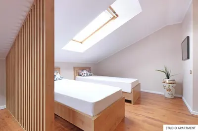 a bedroom with two beds and a skylight at Downtown Belgrade Apartments in Belgrade