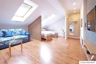 a living room with a blue couch and a bathroom at Downtown Belgrade Apartments in Belgrade