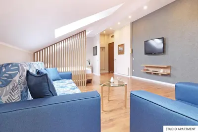 a living room with a blue couch and a tv at Downtown Belgrade Apartments in Belgrade