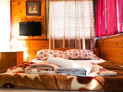 a bed with a pile of blankets and pillows on it at Vila Aleksandar in Smederevo