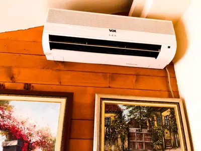 a air conditioner and a printer on a wall with two pictures at Vila Aleksandar in Smederevo
