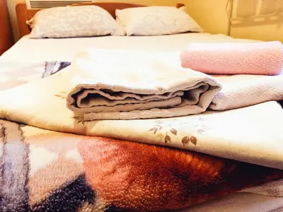 a bed with blankets and pillows on it at Vila Aleksandar in Smederevo