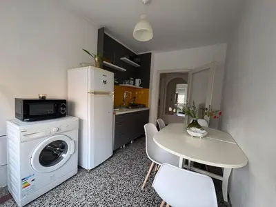 a kitchen with a washing machine and a table with chairs at Star apartment in Belgrade
