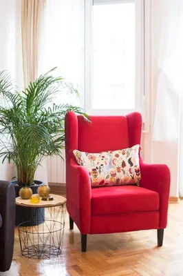 a red chair with a pillow in a living room at City Side Up Exclusive in Belgrade