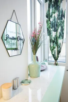 a white vase with flowers on a counter in a room at City Side Up Exclusive in Belgrade