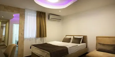 a bedroom with a bed and a window and a couch at Olympic Wellness & Spa Apartments in Belgrade