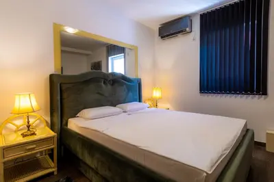 a bedroom with a large bed and a mirror at Olympic Wellness & Spa Apartments in Belgrade