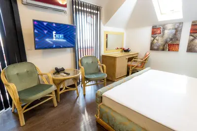a bedroom with a bed and two chairs and a desk at Olympic Wellness & Spa Apartments in Belgrade