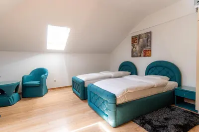 a bedroom with two beds and blue chairs at Olympic Wellness & Spa Apartments in Belgrade