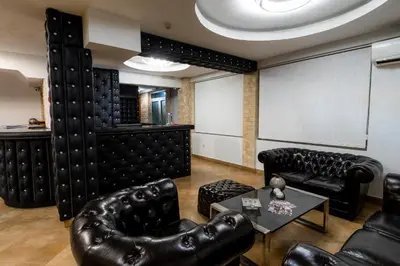 a room with black leather furniture and a large screen at Olympic Wellness & Spa Apartments in Belgrade